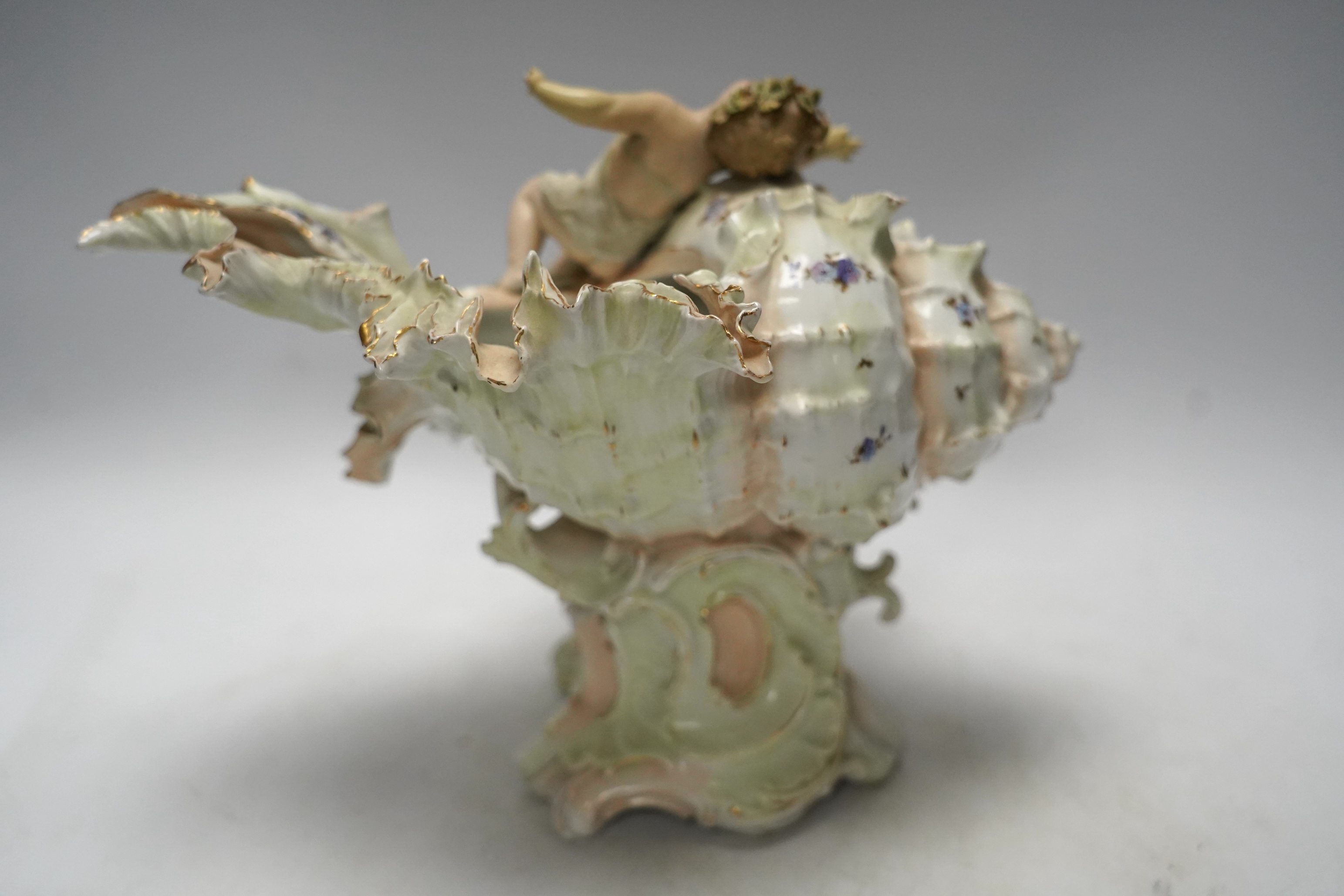 A porcelain shell-shaped centrepiece, a Dresden pill box, a pair of taper holders and a porcelain figure, tallest 21cm